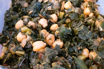 A close-up view of sautéed greens with chickpeas, showcasing a mix of textures and colors in a healthy, appetizing dish