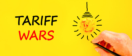 Trade tariff wars symbol. Concept word Tariff wars on beautiful yellow paper. Businessman's hand....