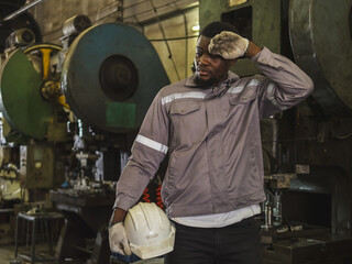 Industrial engineer technician foreman worker man one person with uniform safety vest look and stand and rest from fatigue with heat from work in side manufactory industry metal technology warehouse