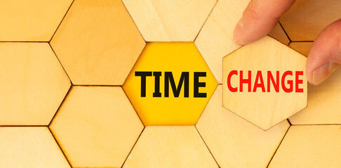 Time change symbol. Concept word Time change on beautiful wooden puzzles. Businessman's hand. Beautiful yellow paper background. Business time change concept. Copy space.