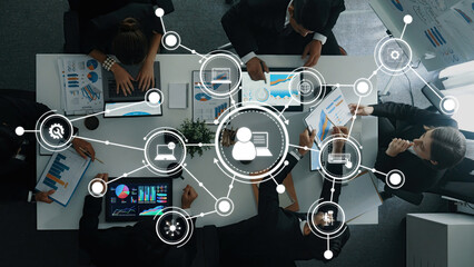 A diverse business team engages in collaboration with digital tools, focusing on data visualization and strategy development in a modern office environment, enhancing productivity. Amity