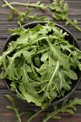 Fototapeta premium Fresh ripe green arugula leaves on dark wooden table, flat lay