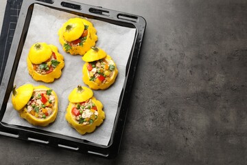 Tasty stuffed pattypan squashes on dark textured table, top view. Space for text