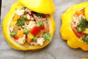Tasty stuffed pattypan squashes on baking paper, top view