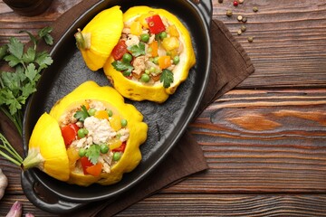 Tasty stuffed pattypan squashes in baking dish on wooden table, flat lay