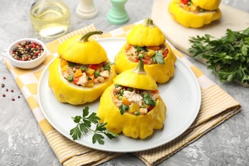 Tasty stuffed pattypan squashes on grey textured table, closeup