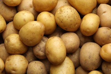 Fresh raw potatoes as background, closeup view
