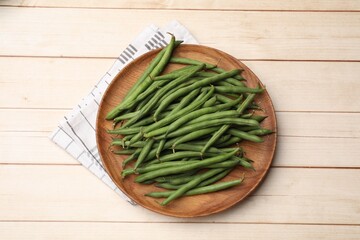 Fresh pea pods on light wooden table, top view