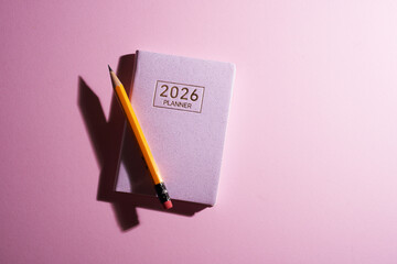 2026 small planner and pen against pink background.