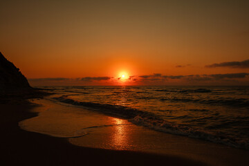 Obraz premium Dramatic sunset over the sea with orange sky and waves