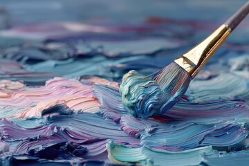 Obraz premium Close-up of a paintbrush dipped in vibrant blue paint, moving over a textured canvas of mixed pastel colors