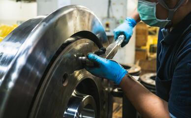 Close-up engineer technician craftsman one person hand wear glove safety protective holding wrench tool tighten torque nut standard value for job repair product in machine workshop industrial factory