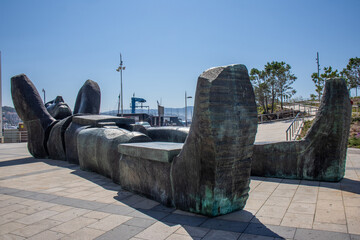 Monumental sculpture of Atlantis, a Greek god of the Atlantic Ocean, lying with his hands on his neck and looking up at the sky. Sanxenxo, Spain