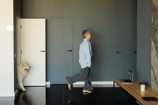 A woman with a dog running around the house