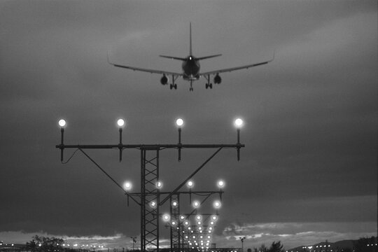 Airplane landing with approach lights in evening sky