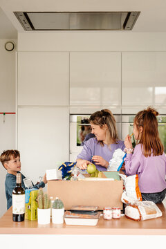 Family engaged in grocery unpacking