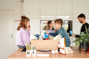 Siblings sorting out delivered groceries