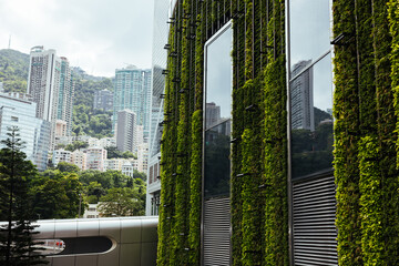 Green vertical garden on modern building with cityscape in background