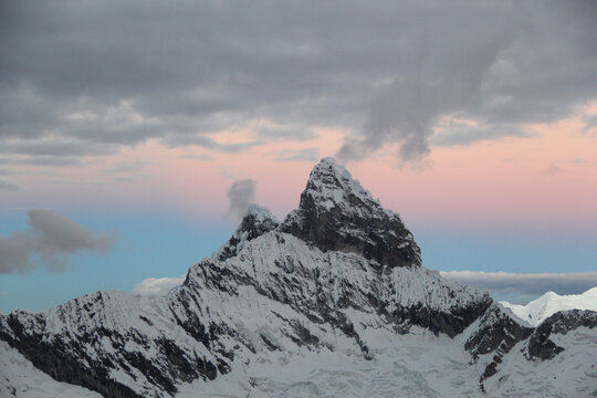 Snow-covered mountain peak with pastel colour sunset.