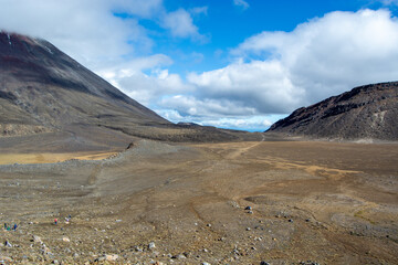 Barren Volcanic Landscape with Mountains and Cloudy Sky
