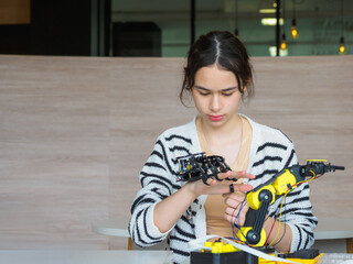 Student young girl smile think show idea development project education learning technology digital wire code proram control robot arm innovation lesson engineer science in laboratory classroom school