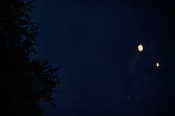 Obraz premium Lanterns gracefully ascend into the night sky, creating a serene and enchanting atmosphere.