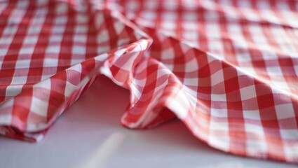 Close up of a red and white checkered tablecloth with a folded pattern