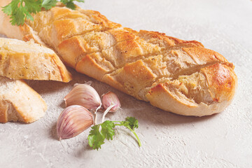 garlic bread,baguette with garlic butter and herbs, on a light table, top view,