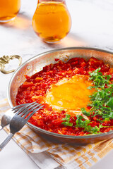 traditional Turkish dish, scrambled eggs with tomatoes, Menemen, with herbs, in a frying pan, close-up, no people,