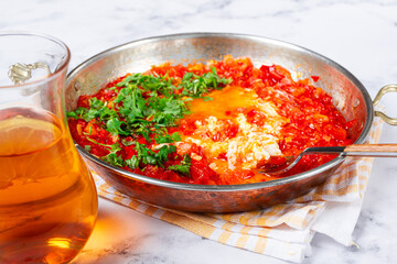 traditional Turkish dish, scrambled eggs with tomatoes, Menemen, with herbs, in a frying pan, close-up, no people,