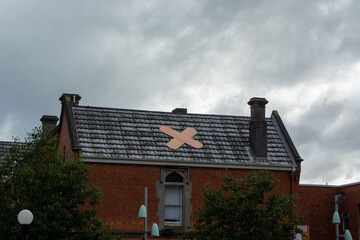 Quirky Band-Aid on Roof of Brick Building