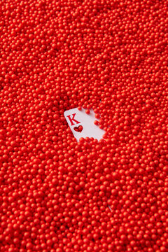 King heart card buried in red balls