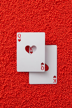 Queen and king heart cards on red balls