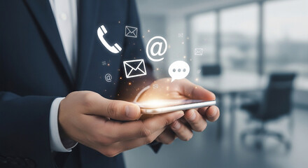 Businessman holding a smartphone displaying communication icons, representing customer service and business connectivity.