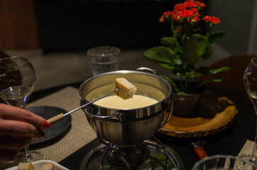 Traditional cheese fondue with bread and a glass of wine.