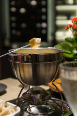 Traditional cheese fondue with bread and a glass of wine.