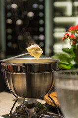 Traditional cheese fondue with bread and a glass of wine.