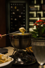 Traditional cheese fondue with bread and a glass of wine.