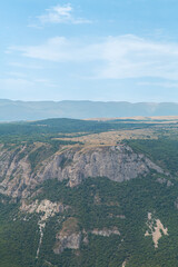 Naklejka premium Mountain ranges covered with green vegetation on a sunny day