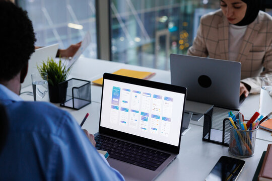 Cropped photo of data analysts working on laptops at open space office