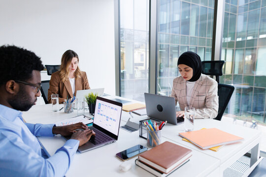Group of designers developing design sitting at one table in office