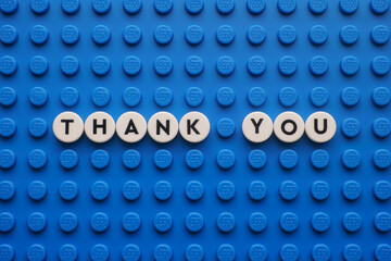 Naklejka premium Tambov, Russian Federation - August 11, 2025 The appreciation phrase Thank You on a blue Lego baseplate. The scene is made out of Lego dots.