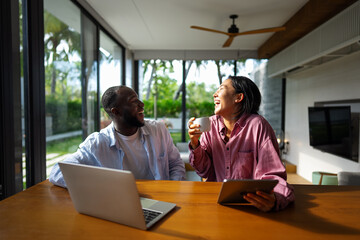 Multicultural couple working remotely, planning finances and investments online. Digital lifestyle