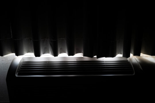 Light Streaming Through Curtains Over an Air Conditioning Unit