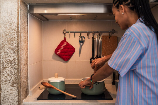 Woman stirring food in pot on induction stove