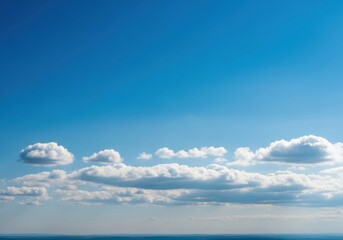 Fototapeta premium Vast blue sky with fluffy white cumulus clouds on a clear summer day, creating a serene and peaceful atmosphere