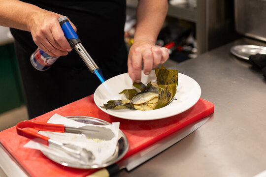 detail of a blowtorch finishing cooking a dish
