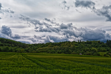 Landscape house on the horizon between a field and a hill