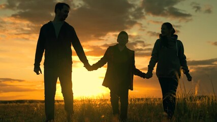Father mother boy teenager happily walking in meadow. Happy family team, dad mom child son travel in nature. Family walking in park sunset, son parents relaxing together outdoors. Parents child dream - Powered by Adobe