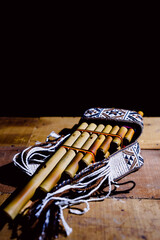 Andean flute and panpipe, traditional musical instruments of the Andes on wood with a black background © roy